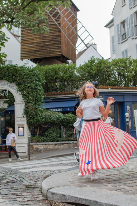 Girl dancing in front of a mill in Montmartre Paris