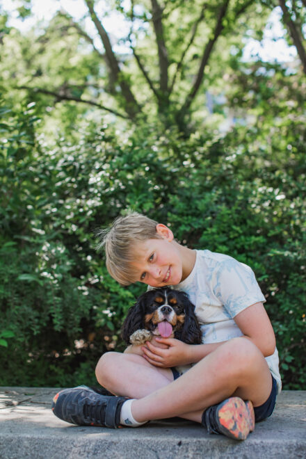 Boy and his dog sitting cross legged at parc Monceau