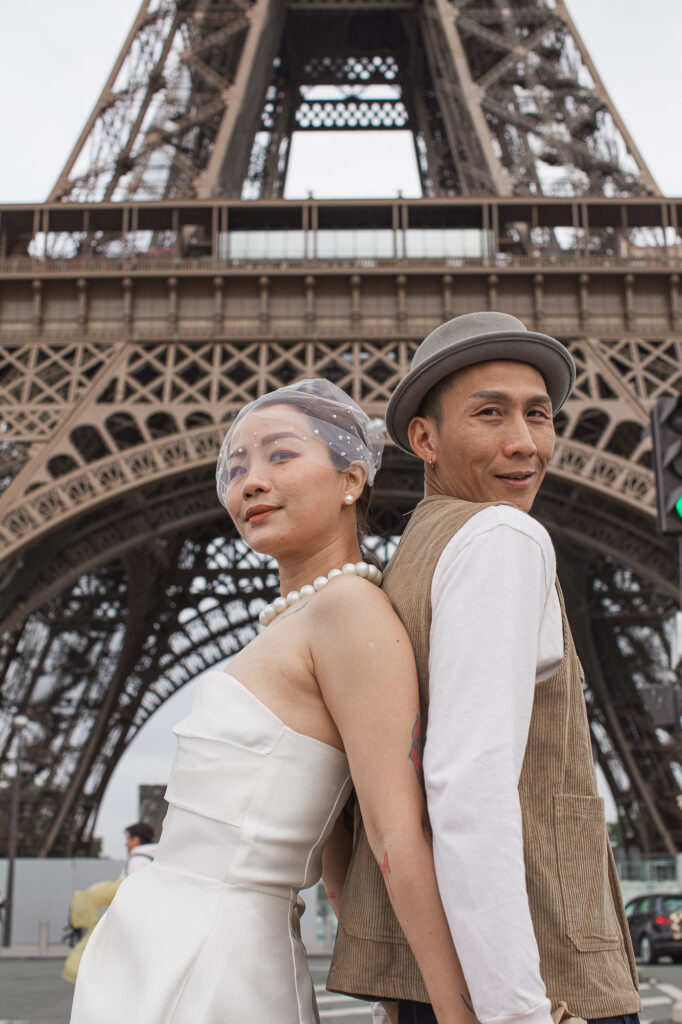 Newlyweds posing at the food of the Eiffel Tower during their elopement in Paris. Radina Dianova - Paris based photographer