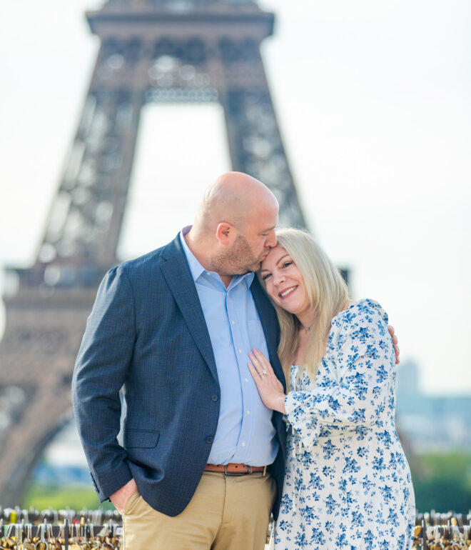 Dan kissing Katie on the forehead as they pose in front of the Eiffel Tower