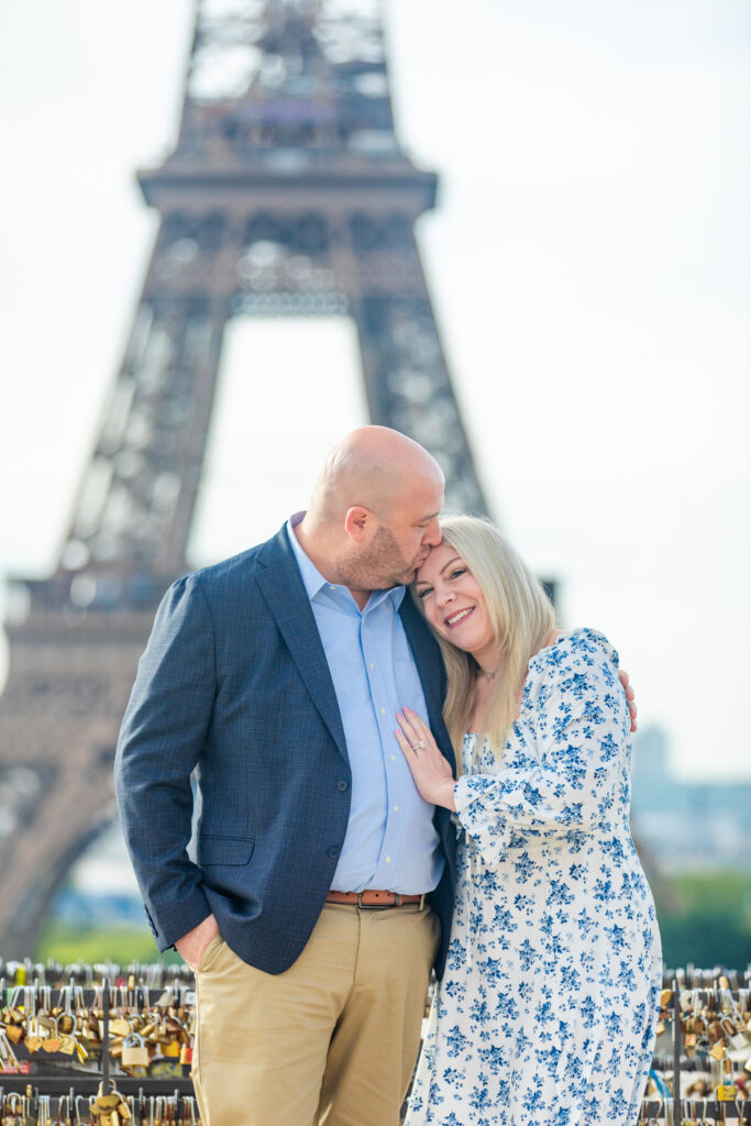 Dan kissing Katie on the forehead as they pose in front of the Eiffel Tower